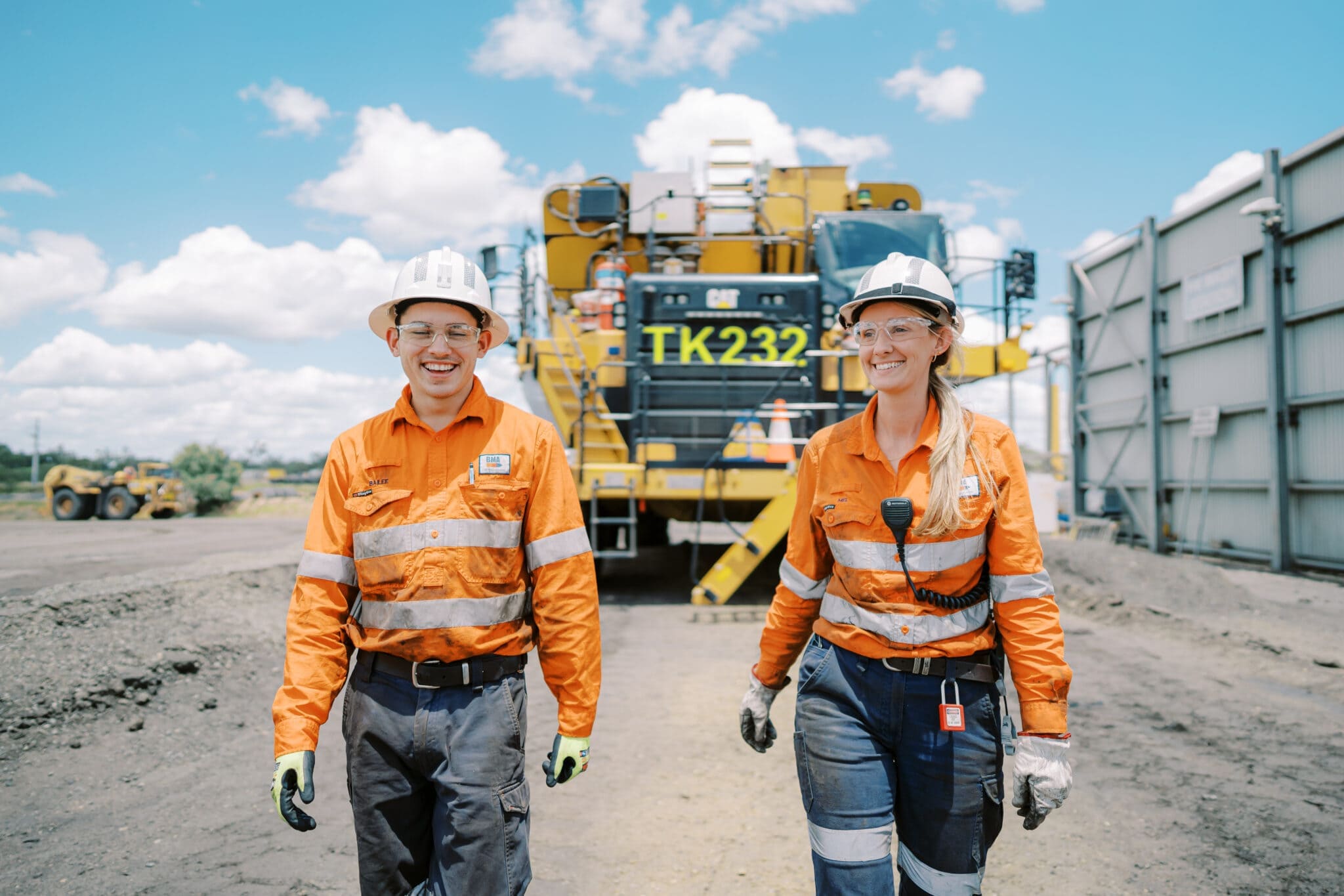 A photo of two BHP workers walking at Caval Ridge as part of their partnership with CleanCo.