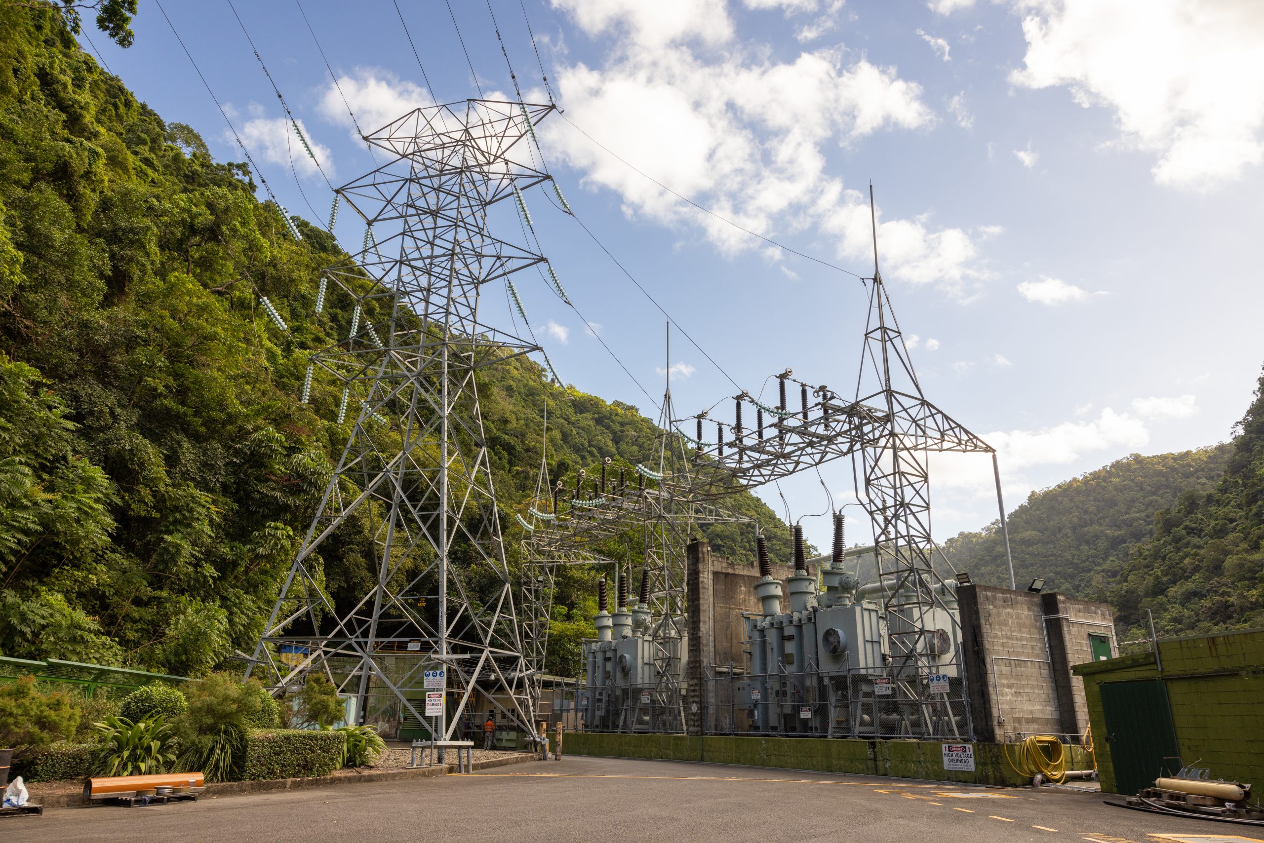 A photograph of the Barron Gorge Substation and Transmission Tower. It is surrounded by green mountains.