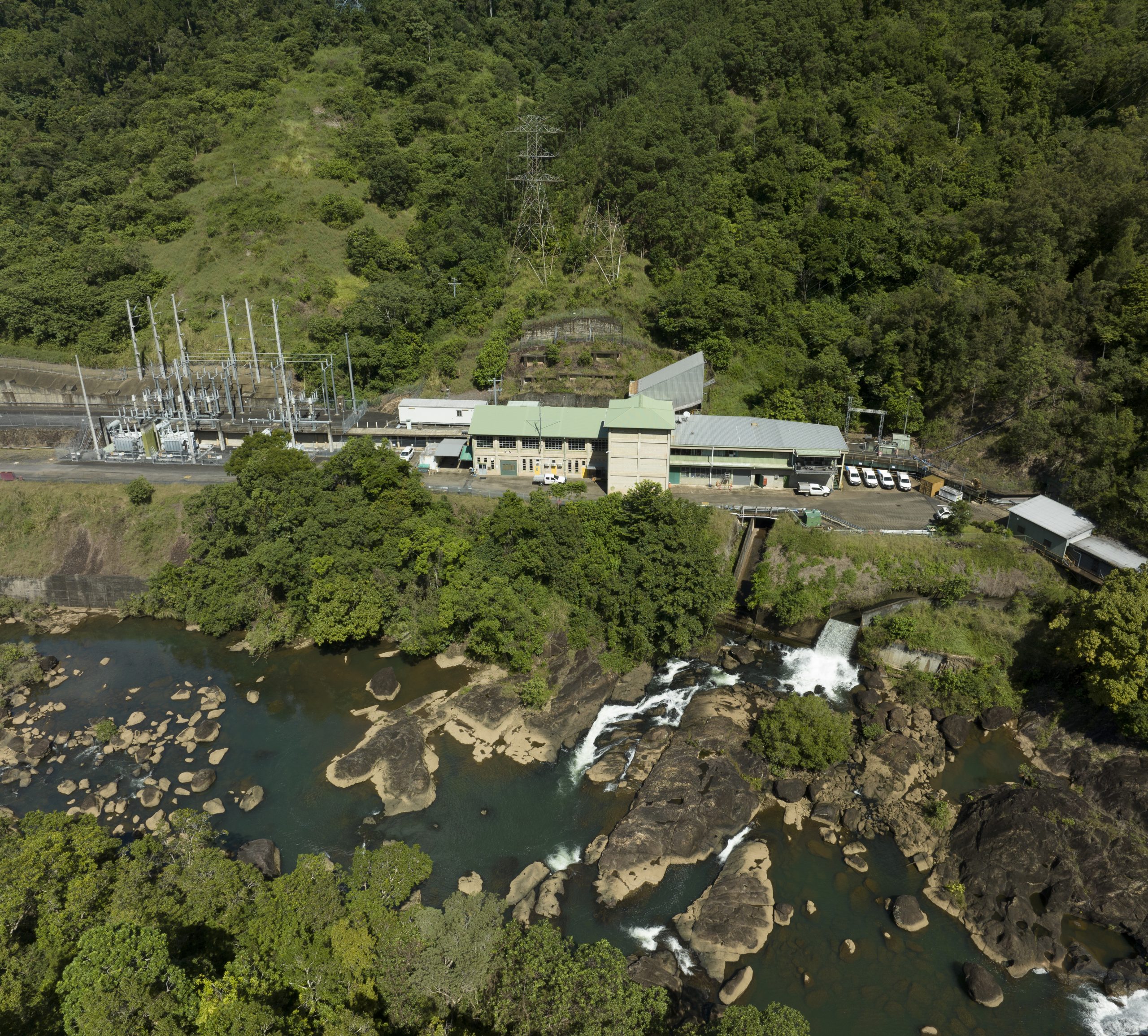 Kareeya Power Station from above on a sunny day. The Power Station is surrounded by lush greenery.