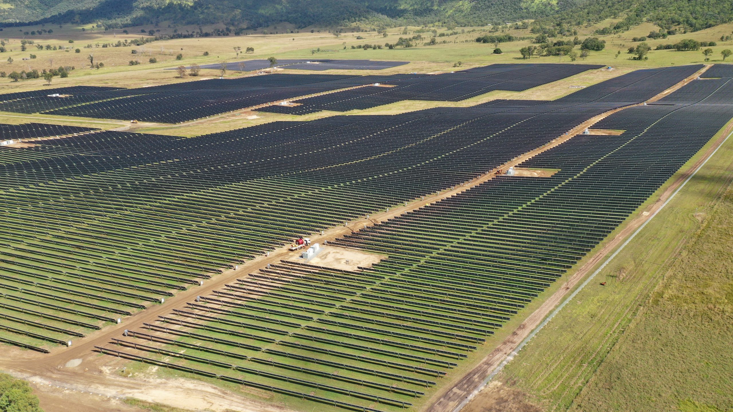 Solar panels of the Woolooga Solar Farm surrounded by paddocks of land.