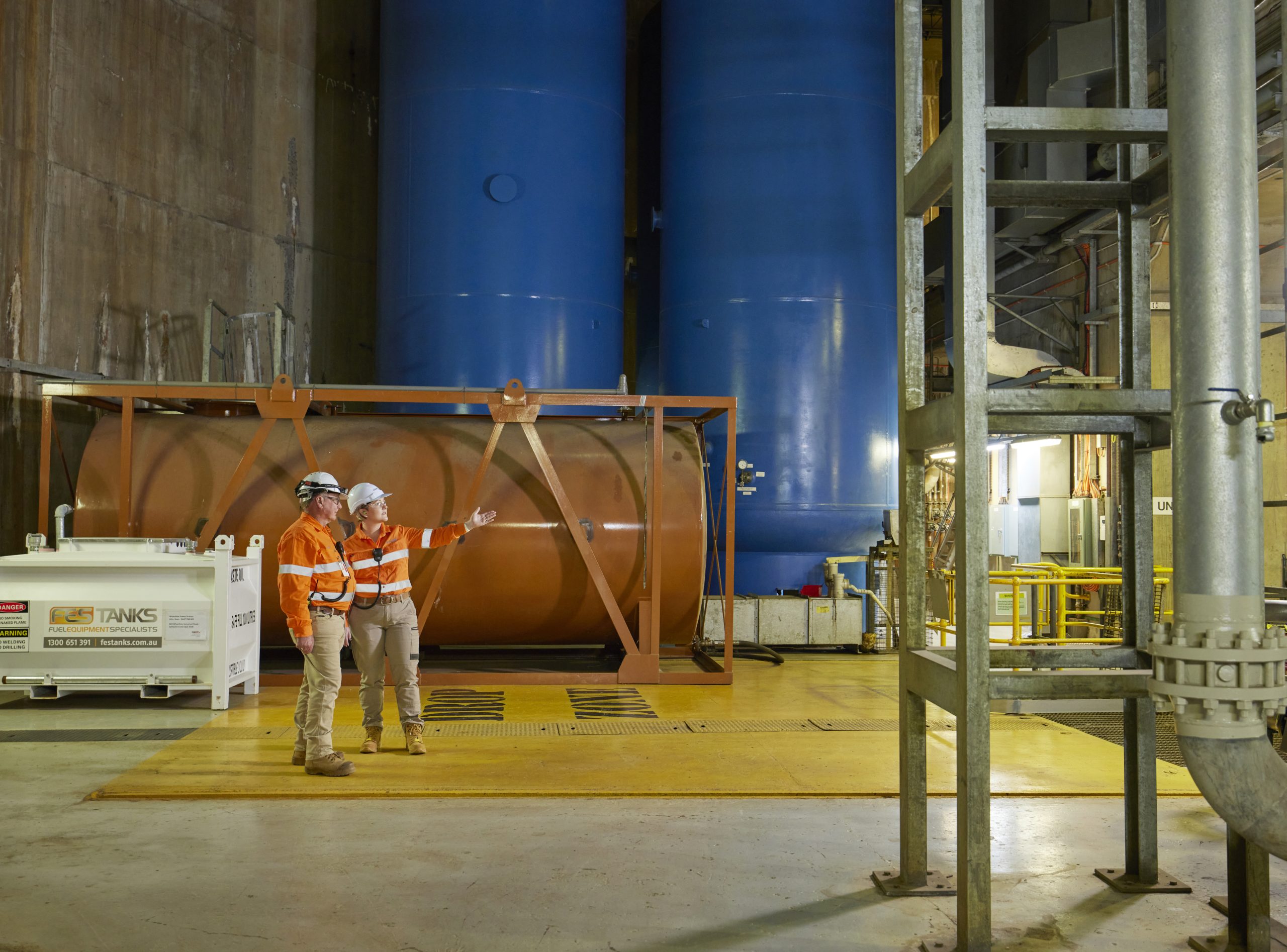 Two Wivenhoe Hydro workers standing and pointing at an object.