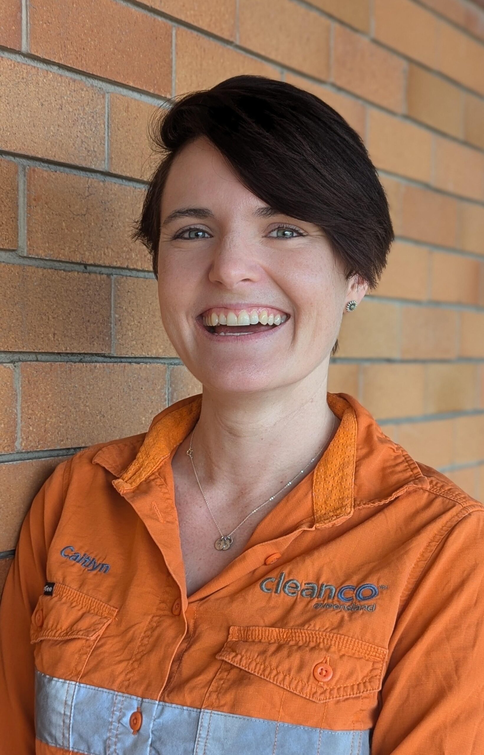 CleanCo Project Manager - Asset Operations (Major Works), Caitlyn, smiles at the camera as she leans against a wall.