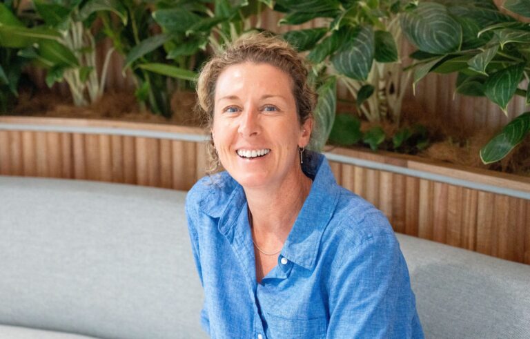 A CleanCo employee sits and smiles at the camera