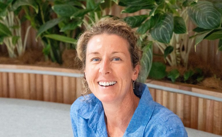 A CleanCo employee sits and smiles at the camera
