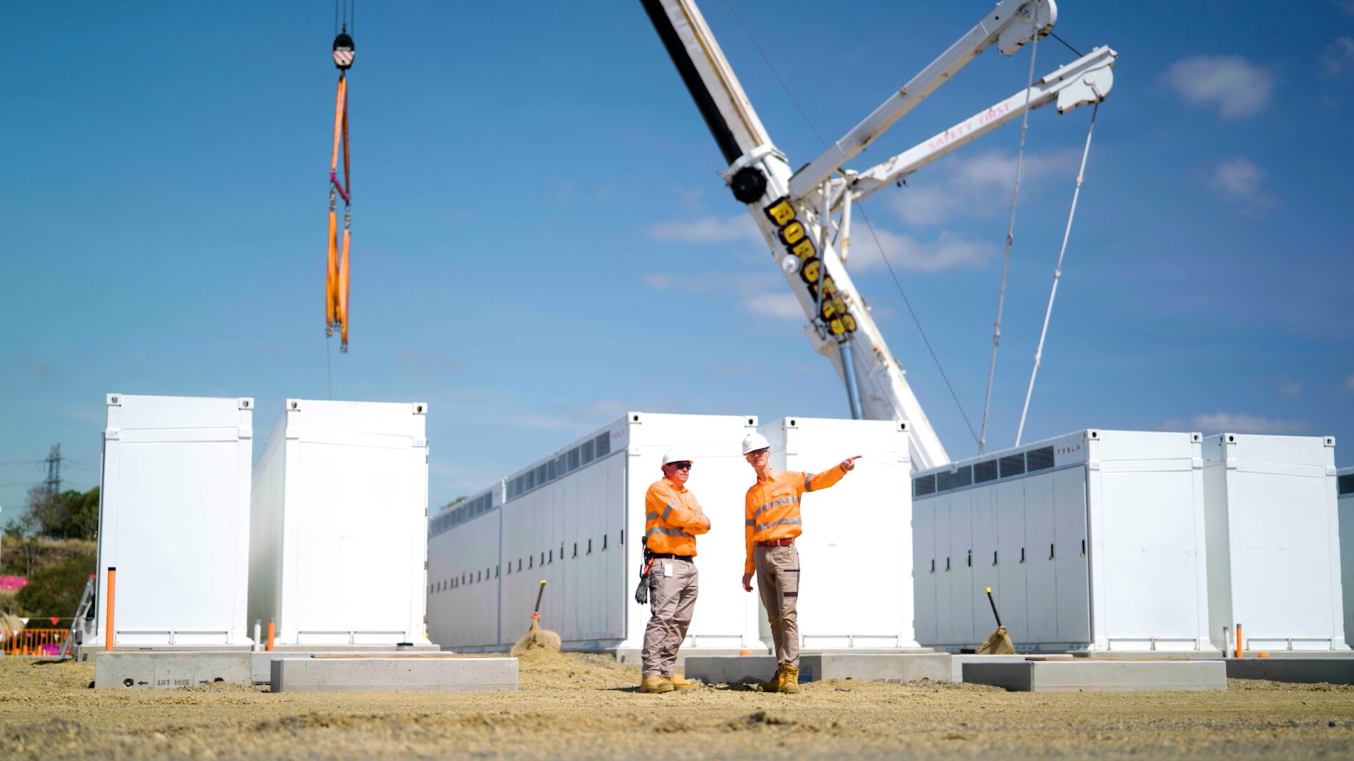 A CleanCo employee stands with the CEO, Tom Metcalfe, at the Swanbank Battery site