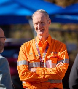 Image of CleanCo CEO Tom Metcalfe smiling dressed in bright orange safety cothing.