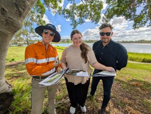 A CleanCo employee stands with contractors at Swanbank Lakeside area. The group is viewing the area to be revialised as part of a CleanCo community project.